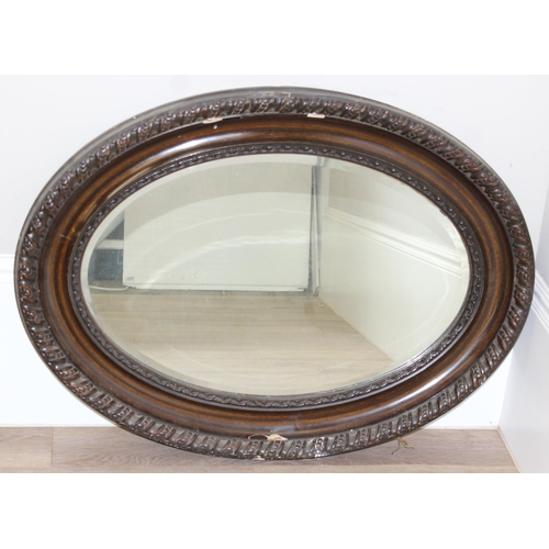 361 - A vintage oval shaped wooden effect wall mirror, approx 95cm x 70cm