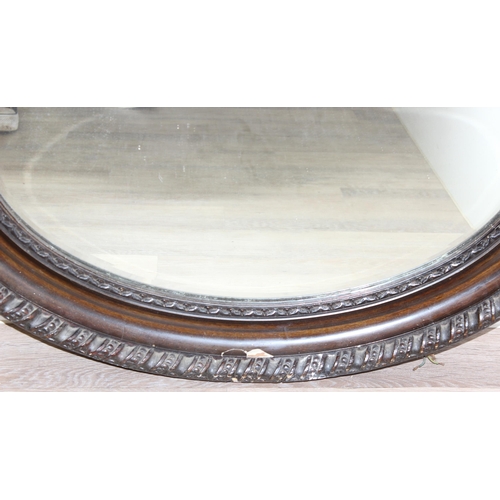 361 - A vintage oval shaped wooden effect wall mirror, approx 95cm x 70cm