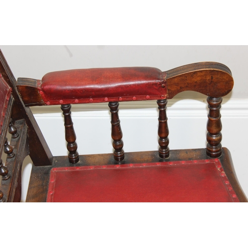 173 - An antique rocking chair with red leather effect upholstery, possibly American, approx 55cm wide x 1... 