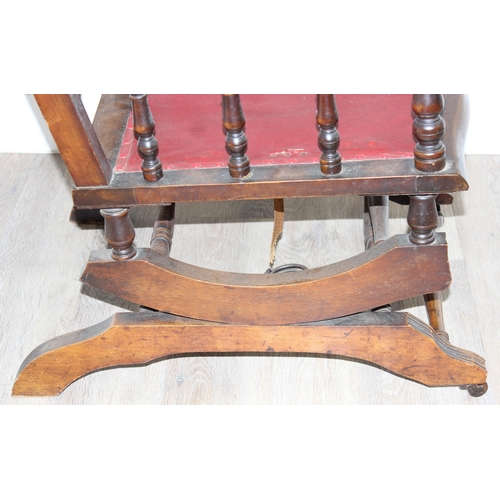 173 - An antique rocking chair with red leather effect upholstery, possibly American, approx 55cm wide x 1... 