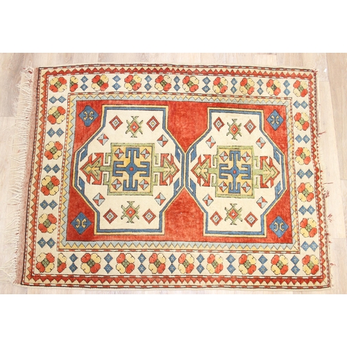 204 - A vintage multi-coloured wool rug with orange and cream ground and geometric patterns, approx 175cm ... 