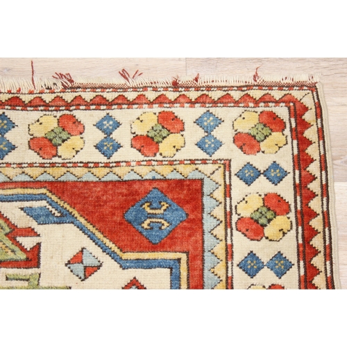 204 - A vintage multi-coloured wool rug with orange and cream ground and geometric patterns, approx 175cm ... 