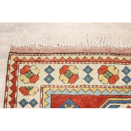 204 - A vintage multi-coloured wool rug with orange and cream ground and geometric patterns, approx 175cm ... 