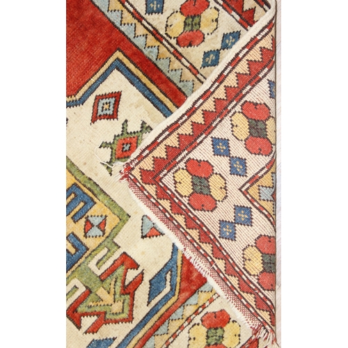 204 - A vintage multi-coloured wool rug with orange and cream ground and geometric patterns, approx 175cm ... 