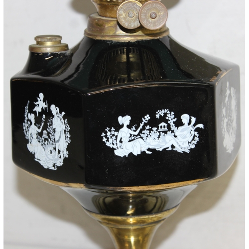 245 - A vintage oil lamp with brass base, black printed glass reservoir and green glass shade, approx 55cm... 