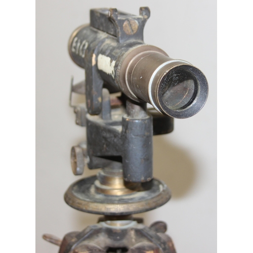 727 - A vintage painted brass theodolite on wooden tripod base, both seemingly unmarked, approx 145cm tall... 