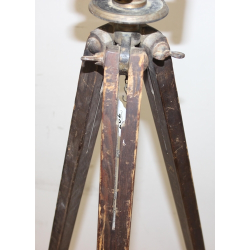 727 - A vintage painted brass theodolite on wooden tripod base, both seemingly unmarked, approx 145cm tall... 