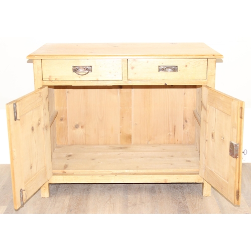 8 - An antique stripped pine cupboard or sideboard with 2 drawers over a 2 door cupboard, with black pai... 