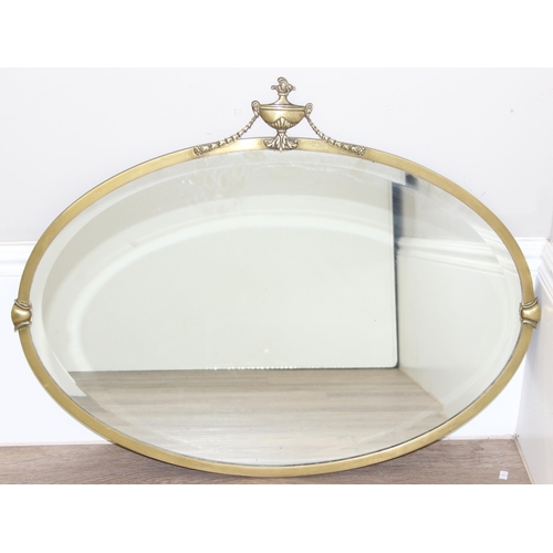 394 - A vintage brass framed oval wall mirror with urn and swag decoration, approx 81cm x 62cm