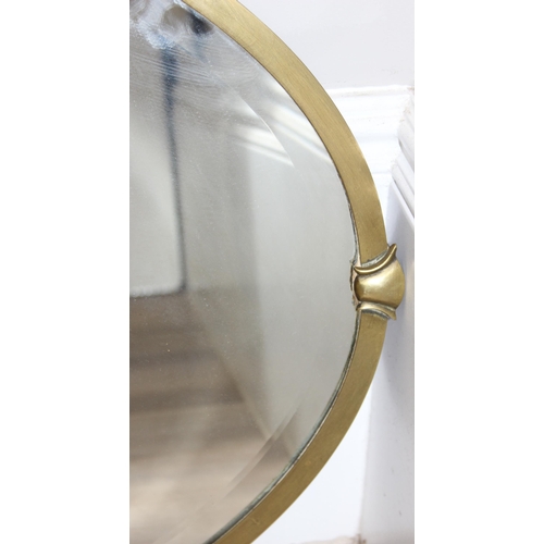 394 - A vintage brass framed oval wall mirror with urn and swag decoration, approx 81cm x 62cm