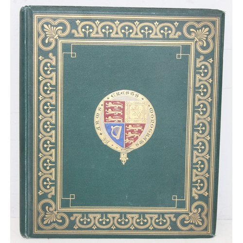 534 - An antique highly decorative cloth bound book containing a large qty of embossed arms crests and mon... 