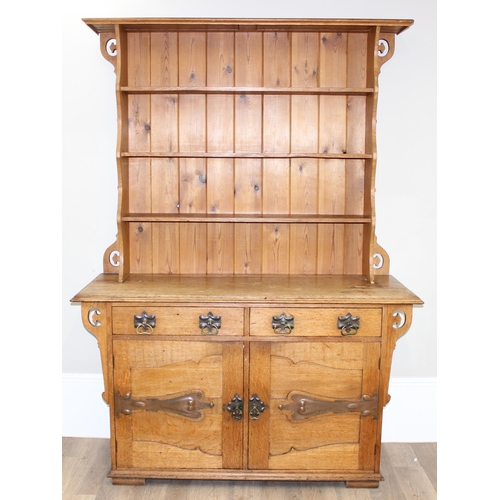 11 - In the manner of Liberty of London, an Arts & Crafts period light oak dresser, with highly decorativ... 