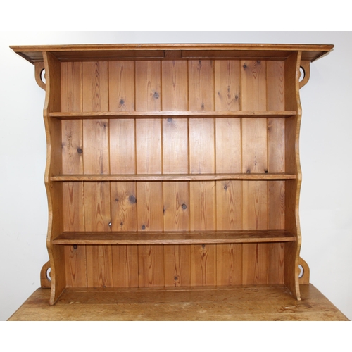 11 - In the manner of Liberty of London, an Arts & Crafts period light oak dresser, with highly decorativ... 