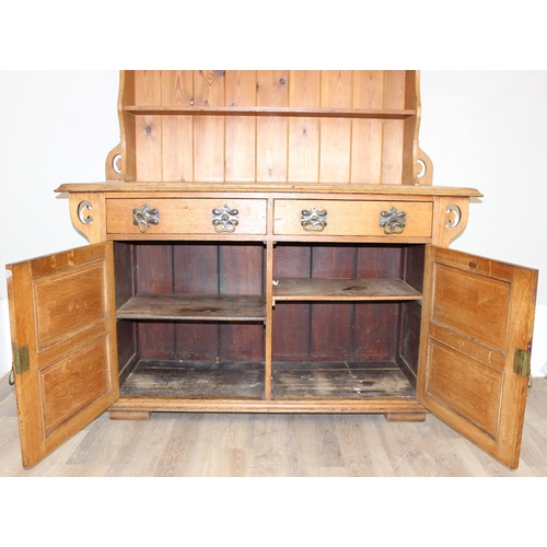 11 - In the manner of Liberty of London, an Arts & Crafts period light oak dresser, with highly decorativ... 