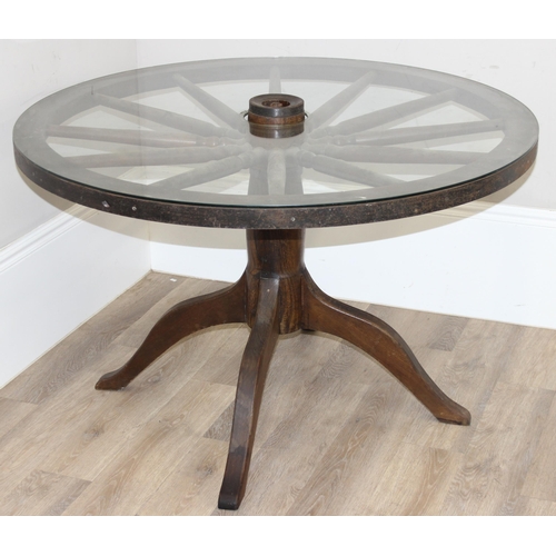 62 - A vintage glass topped table formed from a cartwheel with iron rim, approx 120cm in diameter x 75cm ... 