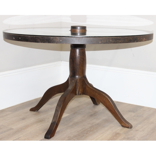 62 - A vintage glass topped table formed from a cartwheel with iron rim, approx 120cm in diameter x 75cm ... 