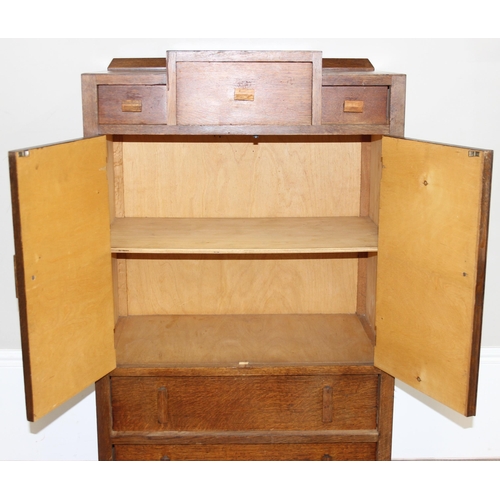 69 - An Art Deco period oak side cabinet with 3 stepped drawers over 2 cupboards over 2 further drawers, ... 