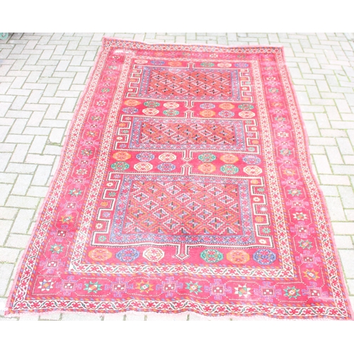 206 - A vintage large red ground rug with 3 geometric gul and decorative border, believed to be a Shiraz r... 