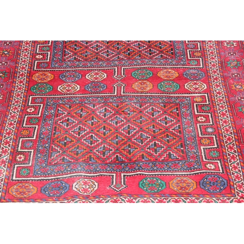 206 - A vintage large red ground rug with 3 geometric gul and decorative border, believed to be a Shiraz r... 