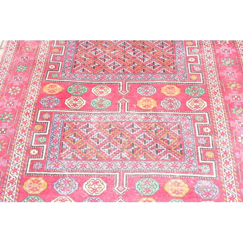 206 - A vintage large red ground rug with 3 geometric gul and decorative border, believed to be a Shiraz r... 