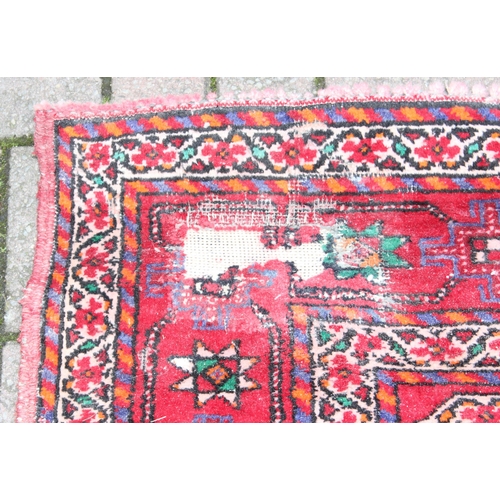 206 - A vintage large red ground rug with 3 geometric gul and decorative border, believed to be a Shiraz r... 