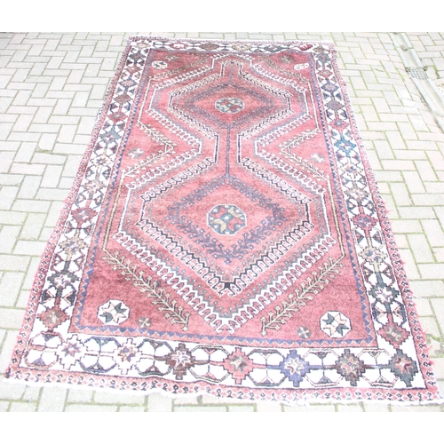 208 - A large vintage red ground and cream rug with geometric designs, worn, possibly Turkish, approx 295c... 