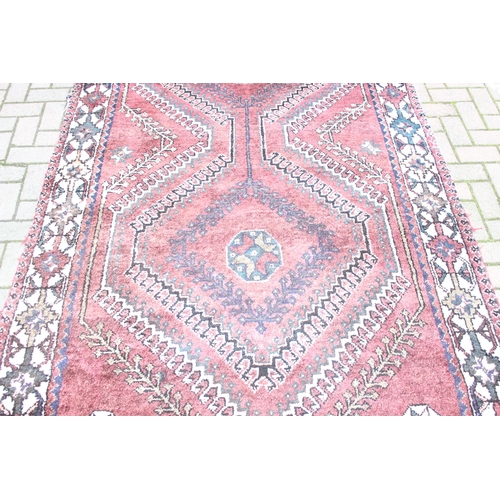 208 - A large vintage red ground and cream rug with geometric designs, worn, possibly Turkish, approx 295c... 