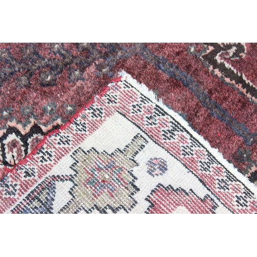 208 - A large vintage red ground and cream rug with geometric designs, worn, possibly Turkish, approx 295c... 