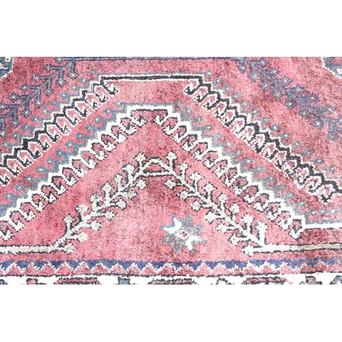 208 - A large vintage red ground and cream rug with geometric designs, worn, possibly Turkish, approx 295c... 