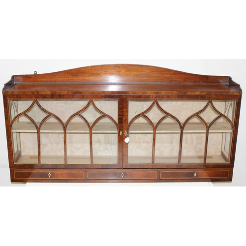 64 - An unusual antique mahogany wall-mountable Gothic style glazed cabinet with three drawers and inlaid... 