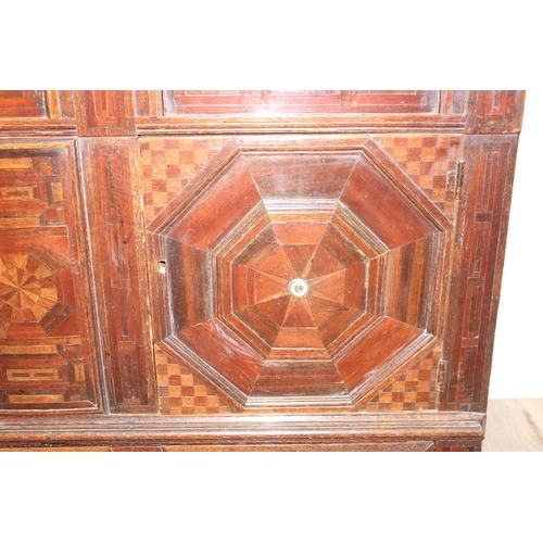 19 - An extremely unusual antique cupboard with single drawer to base and geometric parquetry design, bel... 