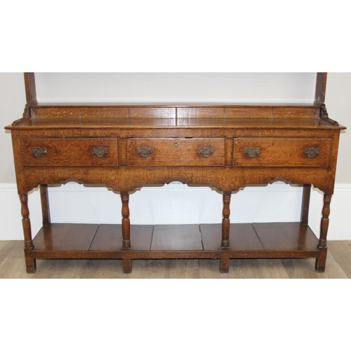 17 - A large antique country oak dresser with plate rack, likely early 19th century, the base set with 3 ... 