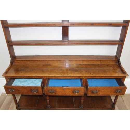 17 - A large antique country oak dresser with plate rack, likely early 19th century, the base set with 3 ... 