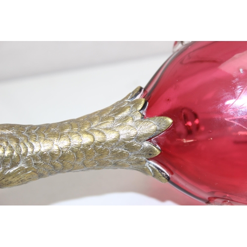 1058 - A rare cranberry glass and silver plate mounted decanter or claret jug formed as a duck, the feet ma... 