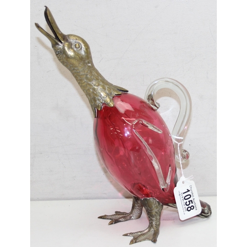 1058 - A rare cranberry glass and silver plate mounted decanter or claret jug formed as a duck, the feet ma... 