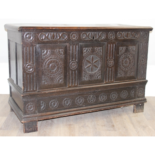 20 - An 18th century carved oak coffer, the carvings depicting geometric roundels and stylised floral car... 