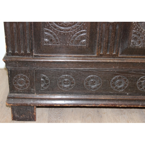 20 - An 18th century carved oak coffer, the carvings depicting geometric roundels and stylised floral car... 