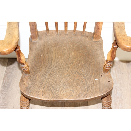 71 - An antique elm seated farmhouse Windsor armchair with stick back, approx 56cm wide x 100cm tall