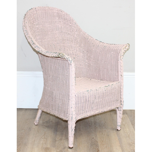 79 - A vintage woven armchair in the manner of Lloyd Loom, over painted label to back, salmon pink distre... 