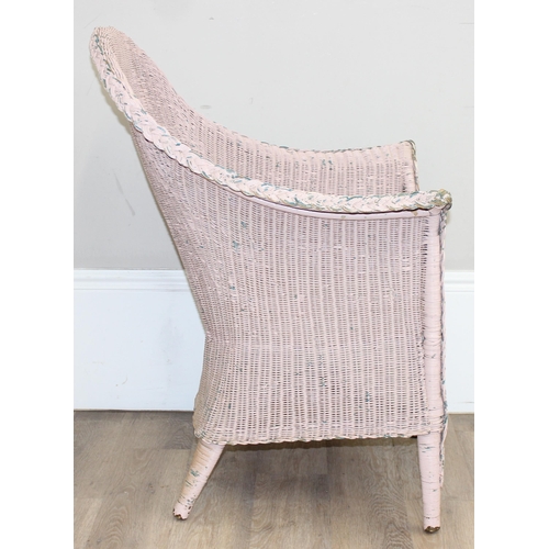 79 - A vintage woven armchair in the manner of Lloyd Loom, over painted label to back, salmon pink distre... 