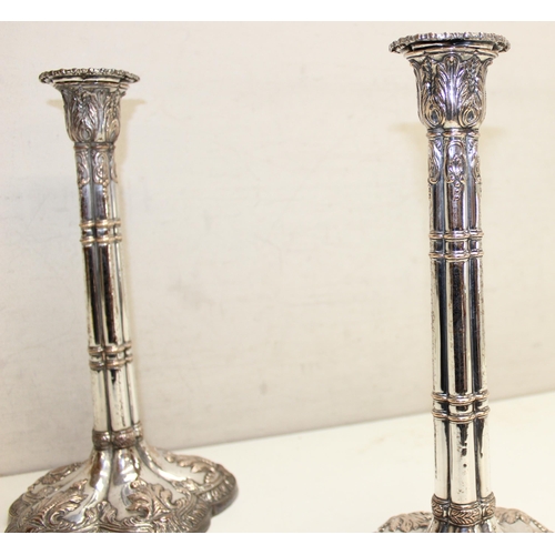 1066 - A pair of mid-18th century style silver plated candlesticks decorated with embossed acanthus scrolls... 