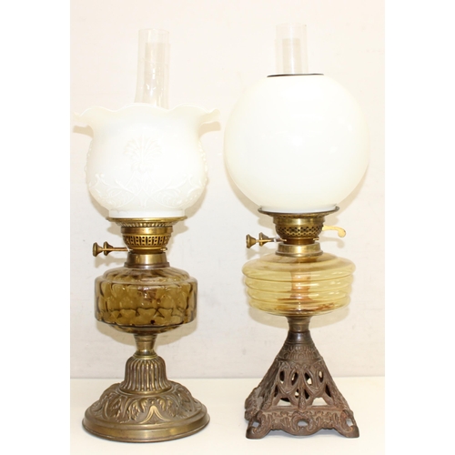 264 - 2 Antique oil lamps with milk glass shades, a glass reservoir, one with cast iron base and the other... 