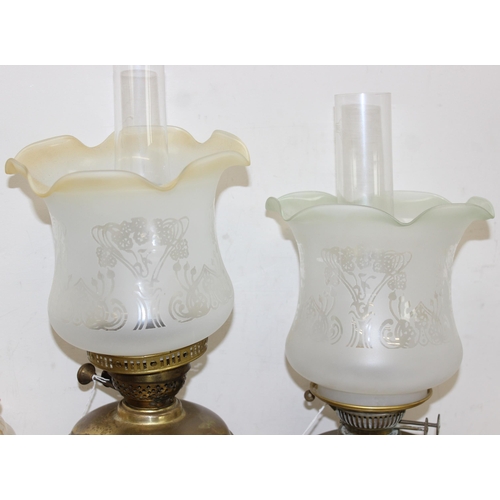 265 - 4 various oil lamps to include 2 with acid etched art nouveau glass shades, and 2 further spare glas... 