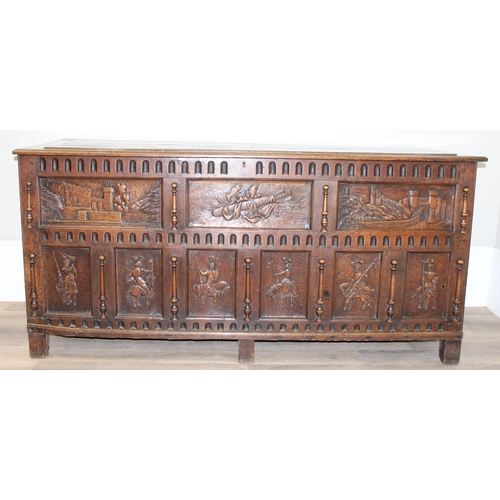 23 - An impressive antique oak coffer with carved details, the body of unusual large proportions with peg... 