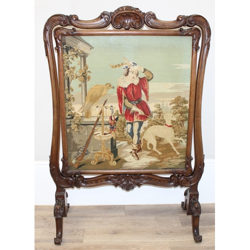 156 - An impressive Victorian fire screen with carved mahogany frame, the revolving centre showing a tapes... 