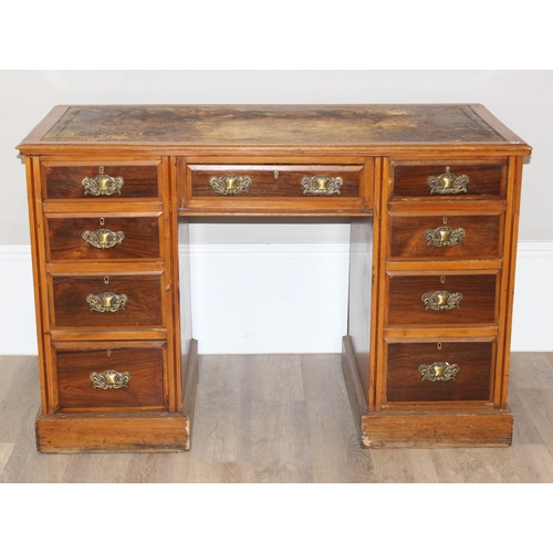 165 - A vintage kneehole desk with 9 drawers and brass handles, distressed leather inset top, approx 122cm... 