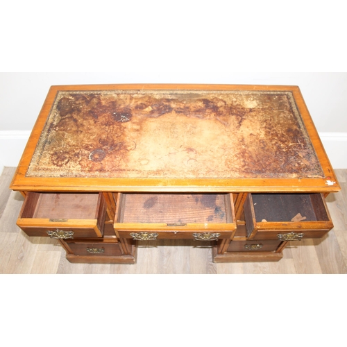 165 - A vintage kneehole desk with 9 drawers and brass handles, distressed leather inset top, approx 122cm... 