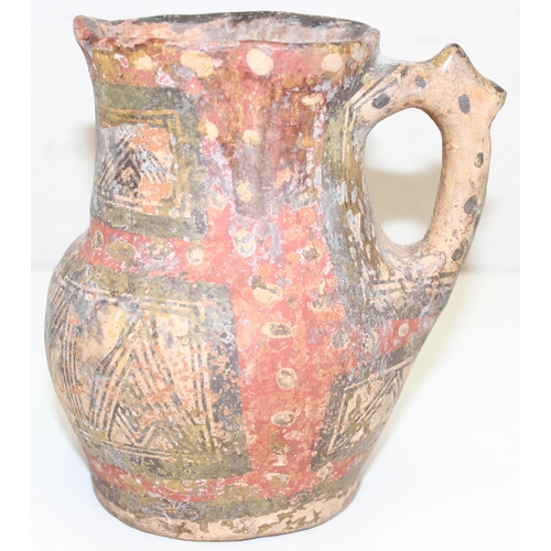 1455 - An unusual antique pottery jug with red spotted decoration and geometric painted decoration, approx ... 