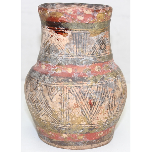 1455 - An unusual antique pottery jug with red spotted decoration and geometric painted decoration, approx ... 