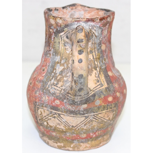 1455 - An unusual antique pottery jug with red spotted decoration and geometric painted decoration, approx ... 